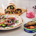 Tallrik med wrap med ABBA matjessill, rödkål, äpple, babyspenat och picklad rödlök.