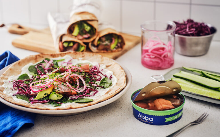Tallrik med wrap med ABBA matjessill, rödkål, äpple, babyspenat och picklad rödlök.