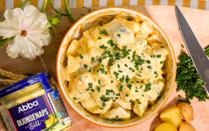 Skål med sill- och potatissallad med Abba Dijonsenapssill toppad med finklippt gräslök.